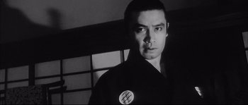 Movie still from “The Sword of Doom” (1966), directed by Kihachi Okamoto – A black and white photo of a man in a kimono; Close Up shot, Low angle