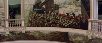 Movie still from “The Tailor of Panama” (2001), directed by John Boorman – A painting of people working on a train track; Extreme Wide shot, Low angle