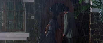 Movie still from “The Tailor of Panama” (2001), directed by John Boorman – A man in a suit and a man in a suit and tie; Wide shot, Low angle