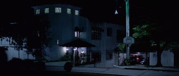 Movie still from “The Tailor of Panama” (2001), directed by John Boorman – A night time picture of a building in the dark; Extreme Wide shot, Low angle