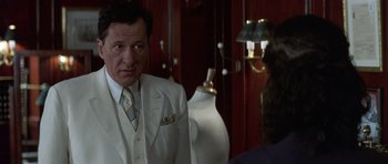 Movie still from “The Tailor of Panama” (2001), directed by John Boorman – A man in a white suit and tie looking at a woman in a white suit; Close Up shot, Over the shoulder angle