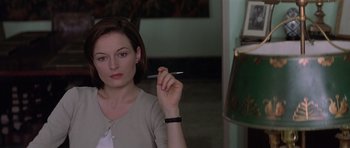 Movie still from “The Tailor of Panama” (2001), directed by John Boorman – A woman is holding a pen in her right hand; Close Up shot, Over the shoulder angle