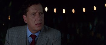 Movie still from “The Tailor of Panama” (2001), directed by John Boorman – A person wearing a suit and tie; Close Up shot, Low angle