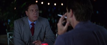 Movie still from “The Tailor of Panama” (2001), directed by John Boorman – Two men sitting at a table with a cigarette in their mouth; Close Up shot, Over the shoulder angle