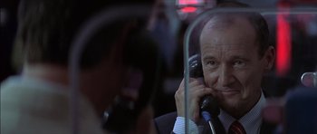 Movie still from “The Tailor of Panama” (2001), directed by John Boorman – An older man talking on a phone while sitting in a car; Close Up shot, Low angle