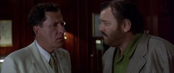 Movie still from “The Tailor of Panama” (2001), directed by John Boorman – Two men are facing each other in a room; Close Up shot, Over the shoulder angle