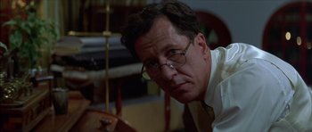 Movie still from “The Tailor of Panama” (2001), directed by John Boorman – A person wearing glasses and a tie; Close Up shot, Low angle