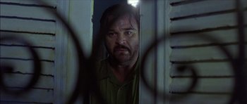 Movie still from “The Tailor of Panama” (2001), directed by John Boorman – A person looking through a window; Close Up shot, Low angle