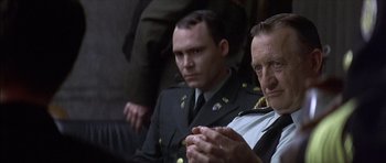 Movie still from “The Tailor of Panama” (2001), directed by John Boorman – Two men in uniform sitting next to each other; Close Up shot, Over the shoulder angle