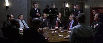 Movie still from “The Tailor of Panama” (2001), directed by John Boorman – A group of men sitting around a table with drinks; Medium shot, Over the shoulder angle