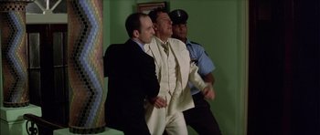 Movie still from “The Tailor of Panama” (2001), directed by John Boorman – A man in a white suit and a man in a black suit and a man in a white suit and a man in a black suit; Medium shot, Low angle