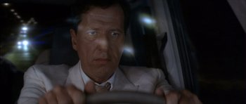 Movie still from “The Tailor of Panama” (2001), directed by John Boorman – A person driving a car at night; Close Up shot, Low angle