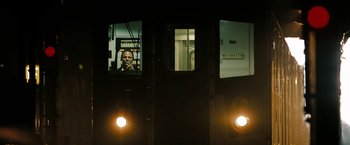 Movie still from “The Taking of Pelham 123” (2009), directed by Tony Scott – A man sitting on a train looking out of a window; Medium shot, Low angle