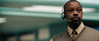 Movie still from “The Taking of Pelham 123” (2009), directed by Tony Scott – A man wearing a headset and a sweater; Close Up shot, Low angle