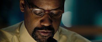 Movie still from “The Taking of Pelham 123” (2009), directed by Tony Scott – A person wearing glasses and a tie; Extreme Close Up shot, Low angle