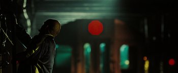 Movie still from “The Taking of Pelham 123” (2009), directed by Tony Scott – A person standing in front of an orange ball; Medium shot, Over the shoulder angle