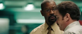 Movie still from “The Taking of Pelham 123” (2009), directed by Tony Scott – A man in a tan shirt and yellow tie; Close Up shot, Over the shoulder angle