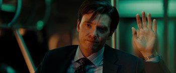 Movie still from “The Taking of Pelham 123” (2009), directed by Tony Scott – A person wearing a suit and tie; Close Up shot, Over the shoulder angle