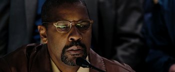 Movie still from “The Taking of Pelham 123” (2009), directed by Tony Scott – A person wearing glasses and a leather jacket; Close Up shot, Low angle