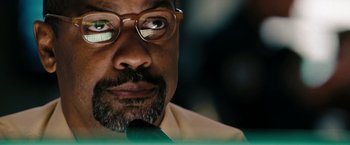 Movie still from “The Taking of Pelham 123” (2009), directed by Tony Scott – A person wearing glasses and a tie; Close Up shot, Low angle