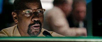 Movie still from “The Taking of Pelham 123” (2009), directed by Tony Scott – A person speaking at a microphone; Close Up shot, Over the shoulder angle