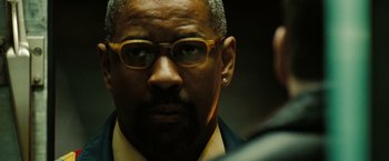 Movie still from “The Taking of Pelham 123” (2009), directed by Tony Scott – A person wearing glasses and a suit; Close Up shot, Low angle