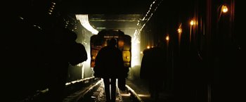 Movie still from “The Taking of Pelham 123” (2009), directed by Tony Scott – People walking down the train tracks in the dark; Wide shot, Low angle