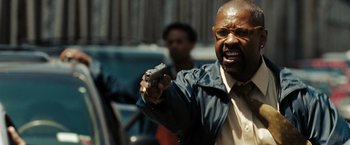 Movie still from “The Taking of Pelham 123” (2009), directed by Tony Scott – A man holding a hand gun in his right hand; Close Up shot, Low angle