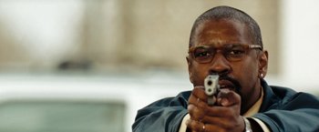 Movie still from “The Taking of Pelham 123” (2009), directed by Tony Scott – A man holding a gun in his right hand; Close Up shot, Low angle