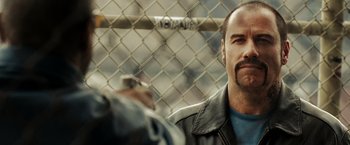 Movie still from “The Taking of Pelham 123” (2009), directed by Tony Scott – A person wearing a leather jacket; Close Up shot, Over the shoulder angle