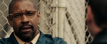 Movie still from “The Taking of Pelham 123” (2009), directed by Tony Scott – A person wearing glasses and a jacket; Close Up shot, Over the shoulder angle