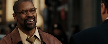 Movie still from “The Taking of Pelham 123” (2009), directed by Tony Scott – An older man wearing a brown jacket and a yellow tie; Close Up shot, Over the shoulder angle