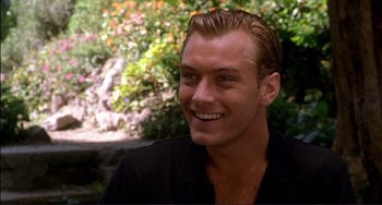 Movie still from “The Talented Mr. Ripley” (1999), directed by Anthony Minghella – A person smiling with trees in the background; Close Up shot, Over the shoulder angle