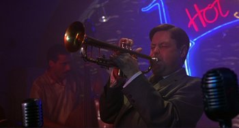 Movie still from “The Talented Mr. Ripley” (1999), directed by Anthony Minghella – A man in a suit playing a trumpet; Close Up shot, Low angle