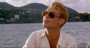 Movie still from “The Talented Mr. Ripley” (1999), directed by Anthony Minghella – A young man wearing a white shirt and a pair of sunglasses; Close Up shot, Low angle
