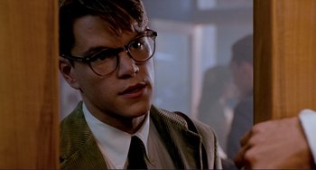 Movie still from “The Talented Mr. Ripley” (1999), directed by Anthony Minghella – A man in a suit and tie wearing glasses and a tie; Close Up shot, Over the shoulder angle