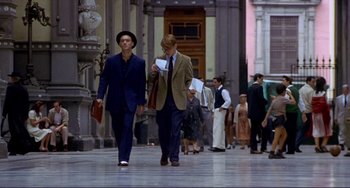 Movie still from “The Talented Mr. Ripley” (1999), directed by Anthony Minghella – A man in a suit walking down a street; Wide shot, Low angle