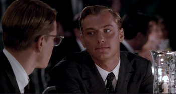 Movie still from “The Talented Mr. Ripley” (1999), directed by Anthony Minghella – A man wearing a suit and tie sitting next to another man; Close Up shot, Over the shoulder angle