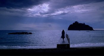 Movie still from “The Talented Mr. Ripley” (1999), directed by Anthony Minghella – A woman standing on a dock looking out at the ocean; Extreme Wide shot, Low angle