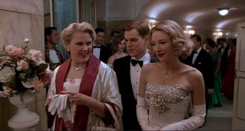 Movie still from “The Talented Mr. Ripley” (1999), directed by Anthony Minghella – A group of people standing next to each other in formal wear; Medium shot, Over the shoulder angle
