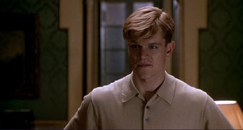 Movie still from “The Talented Mr. Ripley” (1999), directed by Anthony Minghella – A man in a tan shirt is looking at the camera; Close Up shot, Low angle