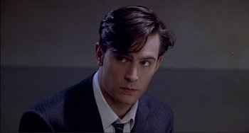 Movie still from “The Talented Mr. Ripley” (1999), directed by Anthony Minghella – A man in a suit and tie looking at the camera; Close Up shot, High angle