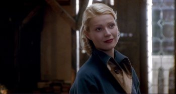 Movie still from “The Talented Mr. Ripley” (1999), directed by Anthony Minghella – A woman with blonde hair wearing a blue jacket; Close Up shot, Over the shoulder angle