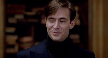 Movie still from “The Talented Mr. Ripley” (1999), directed by Anthony Minghella – A young man in a black jacket smiling; Close Up shot, Over the shoulder angle