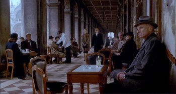 Movie still from “The Talented Mr. Ripley” (1999), directed by Anthony Minghella – A group of people sitting at tables in a room; Wide shot, Over the shoulder angle