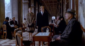 Movie still from “The Talented Mr. Ripley” (1999), directed by Anthony Minghella – A man and a woman standing next to each other in a room; Wide shot, Over the shoulder angle