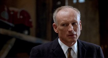 Movie still from “The Talented Mr. Ripley” (1999), directed by Anthony Minghella – An older man in a suit and tie looking to his left; Close Up shot, Low angle