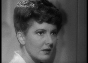 Movie still from “The Talk of the Town” (1942), directed by George Stevens – An old photo of an older woman with short curly hair; Close Up shot, Over the shoulder angle