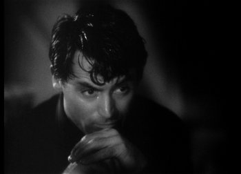 Movie still from “The Talk of the Town” (1942), directed by George Stevens – Black and white photograph of a man with his hand under his chin; Close Up shot, Over the shoulder angle