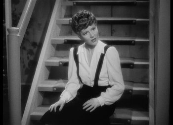 Movie still from “The Talk of the Town” (1942), directed by George Stevens – A woman sitting on top of a set of stairs; Medium shot, High angle